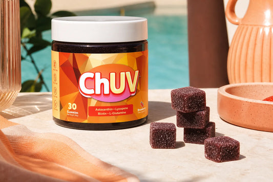 ChUV tanning gummies and bottle on a sun-lit poolside surface representing the astaxanthin vs CoQ10 antioxidant comparison