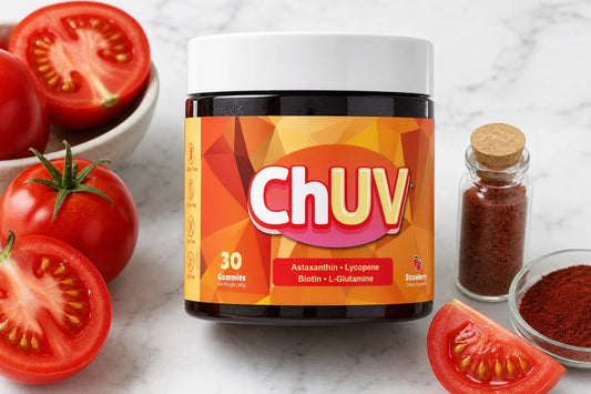 Carotenoids and skin color: ChUV tanning gummies surrounded by ripe tomatoes and a glass vial of Haematococcus algae in warm golden light