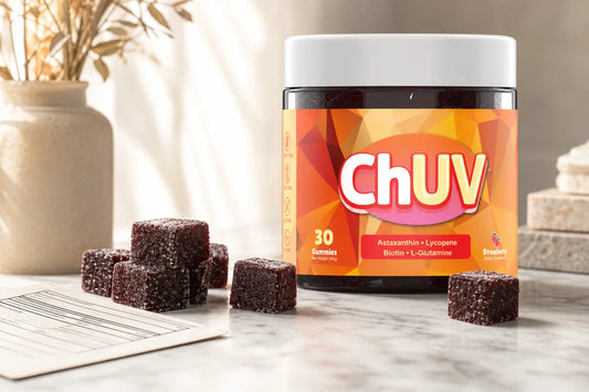 ChUV dark reddish-purple tanning gummy cubes beside a supplement facts panel on white marble, soft natural lighting